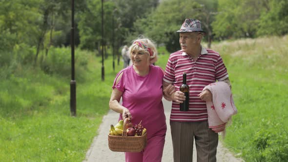 Family Weekend Picnic. Active Senior Old Grandparents Couple in Park. Husband and Wife Walk Together