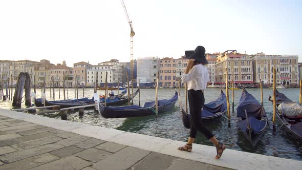 Girl Walking in Venice Near Gondolas, Italy