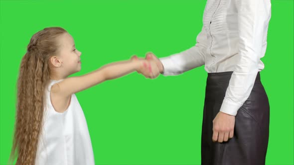 Daughter and Mother Hand Shake on a Green Screen, Chroma Key