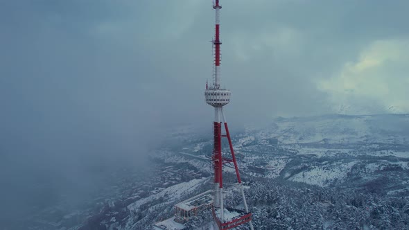 Transmit Masts In The Clouds Above The Snowy City
