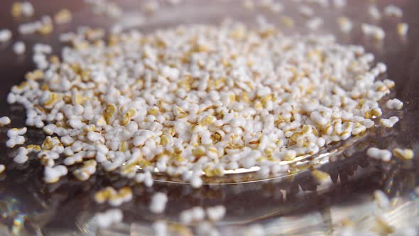 Popped amaranth grains in shiny plate. Dry puffed amaranthus seeds. Macro