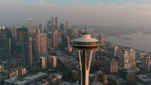 Establishing tight aerial the Space Needle during sunset with Seattle's business district in the bac