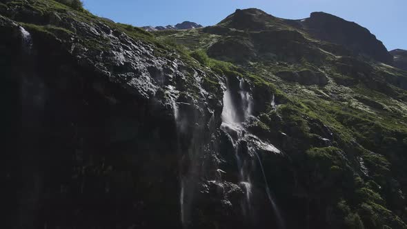 Water Flows Down the Slope of a Mountain Drops Splash From a Huge Rock