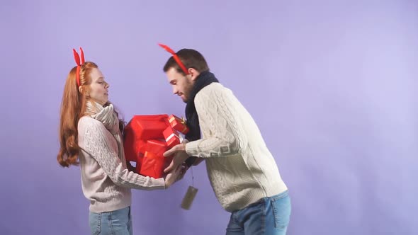 Young Handsome Guy Awkwardly Gives a Variety of Christmas Gifts To His Girlfriend