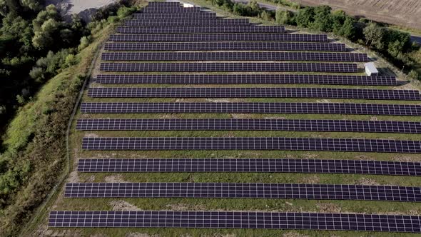 Solar Panels Stands in a Row in Field for Power Production. Drone fly over Solar Farm