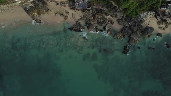Beautiful Bingin beach with exotic cliffs houses and hotel located in Bali, Indonesia. This drone fo