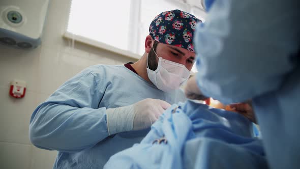 a male surgeon performs an operation