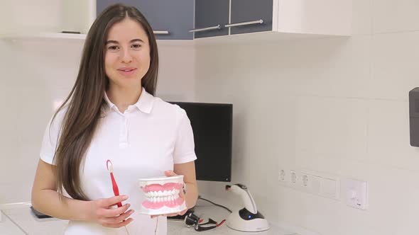 A dentist girl tells about healthy teeth in the dentist's office