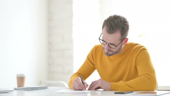 Man Having Disappointment While Writing on Paper