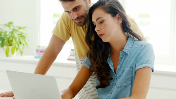 Couple using laptop in the kitchen