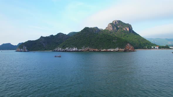 A fisherman is sailing in the sea among the islands near the coast.