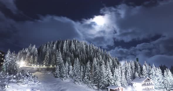 Snowy Mountain With Rolling Clouds Covering The Moon Against The Night Sky - Time Lapse