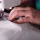 A hand of a young seamstress sewing a white cloth tailoring according to the tradition of tailors. - VideoHive Item for Sale