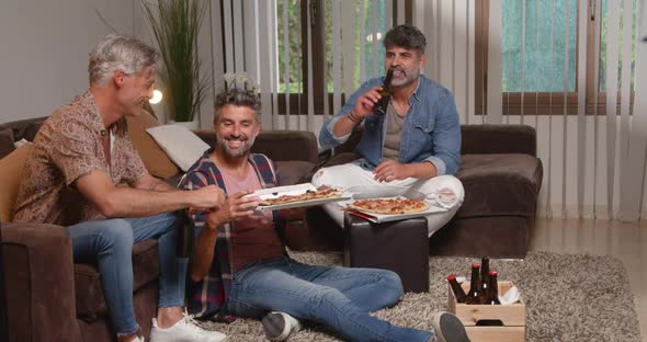 Happy men eating pizza and beer