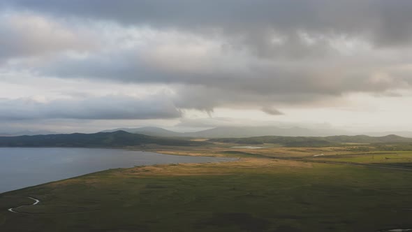 Drone View of a Sunset in a Valley with a River and Mountain Ranges