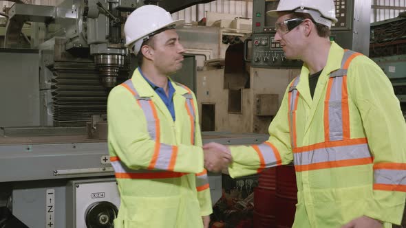 Two engineer man and friend work and greeting with agreement and success together in factory.