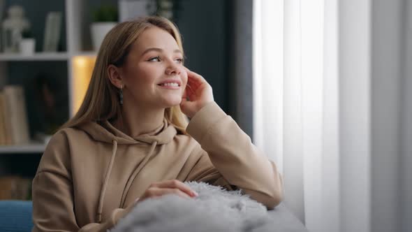 Happy Woman Relaxing Sofa Looking Window