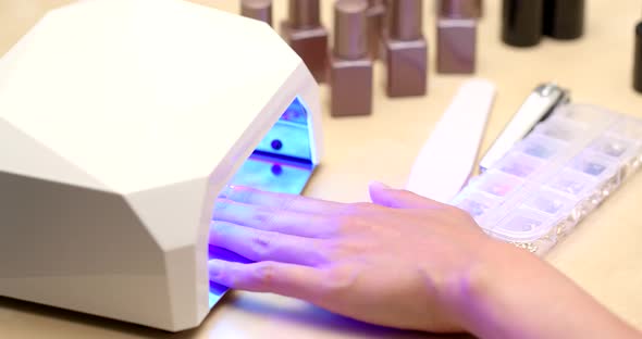 Woman doing Gel nail at home