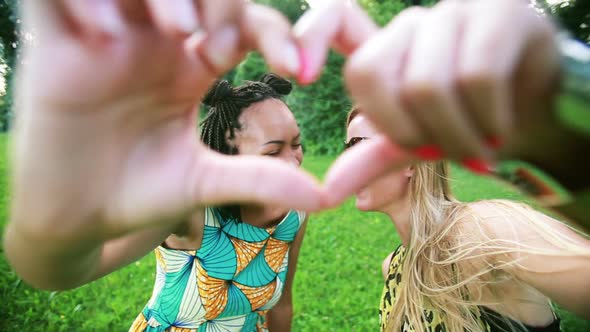 Two young women sending love to the camera