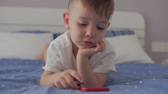 Cute Little Boy Preschool Child Using a Phone or Digital Tablet Technology Device Looks Telephone