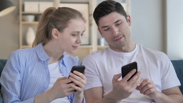 Man and Woman Sharing Information While Using Smartphone