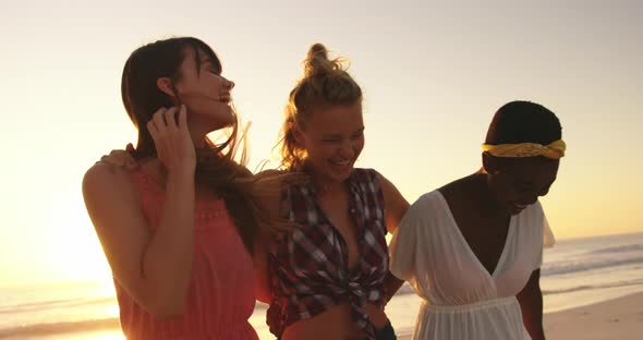 Young adult friends relaxing on the beach at sunset 4k