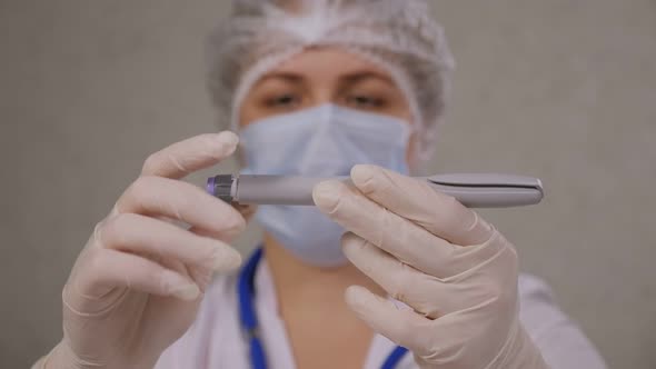 A Closeup of a Doctor in Medical Gloves Dial the Right Dose on an Insulin Pen