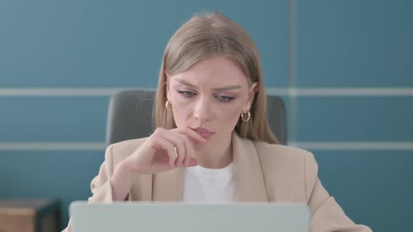 Close Up of Businesswoman Thinking While Working on Laptop in Office