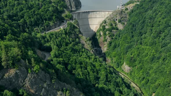 Aerial View of a Hydroelectric Dam in the Mountains Covered with Forest