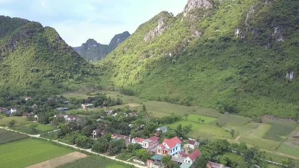 Small Town Surrounded By Fields at Mountains Bird Eye View