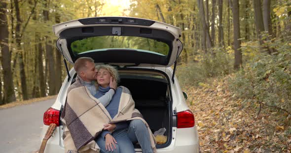 Happy Couple Sitting in a Car in the Autumn Park