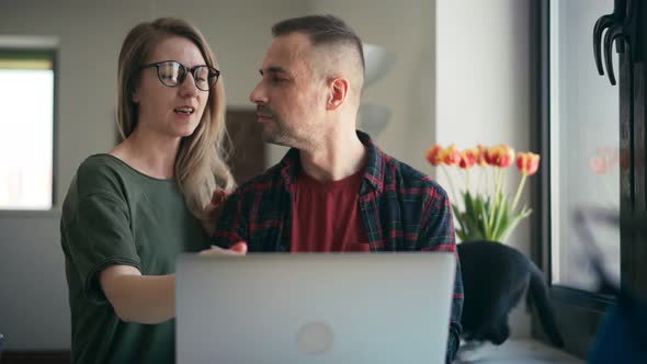 Happy Young Adult Couple Using a Laptop Doing Online Shopping Together