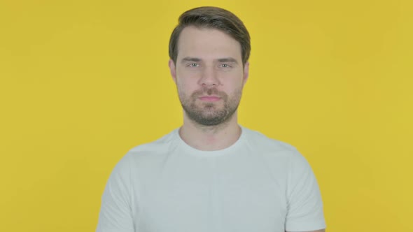 Serious Young Man on Yellow Background