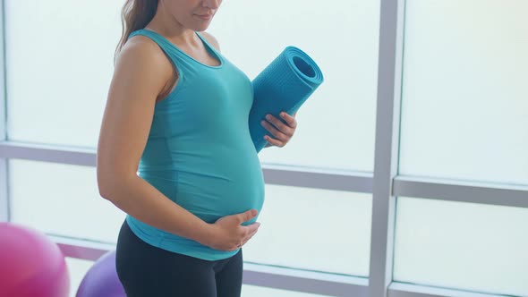 Closeup of a Pregnant Woman's Belly with a Sports Mat