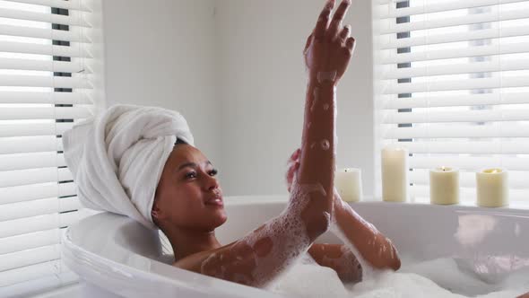 African american woman bathing in the bath tub in the bathroom at home