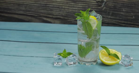 Clear Water in Glass with Green Mint Leaves and Ice Cubes