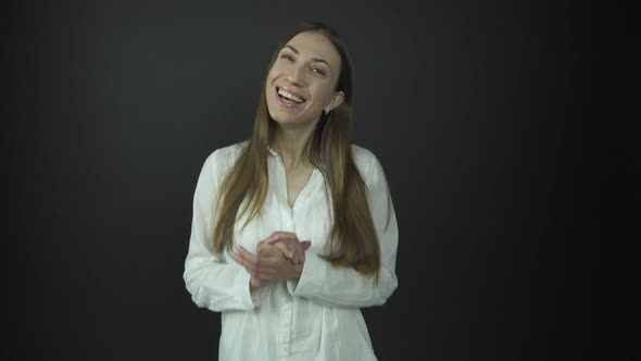 Satisfied Brunette with Long Hair Smiles and Joins Hands