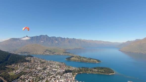 Paragliders flying over Queenstown and Lake Wakatipu with a beautiful mountain background, New Zeala