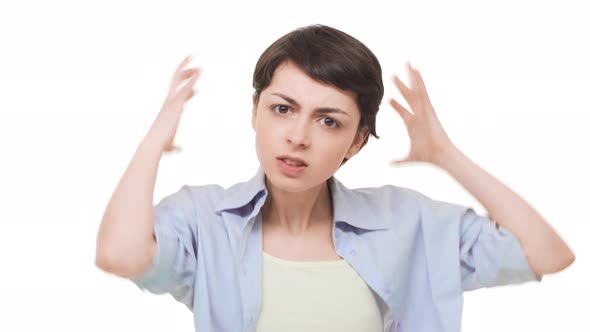 Angry Beautiful Caucasian Female with Short Dark Hair Gesturing Over White Background in