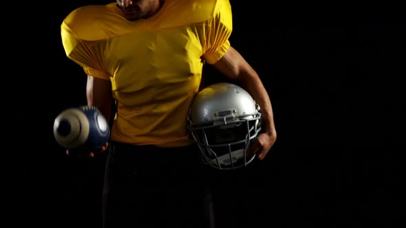 American football player holding head gear and juggling ball 4k