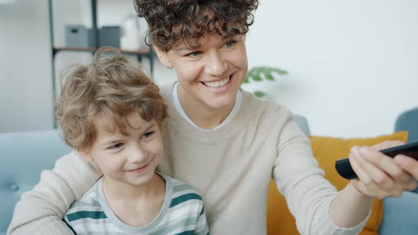 Slow Motion of Happy Kid Watching TV with Loving Mother and Talking Indoors in Apartment