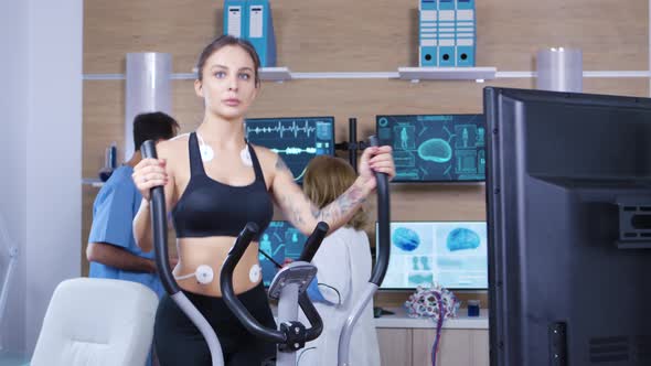 Female Athlete Running with Electrodes Attached To Her Body