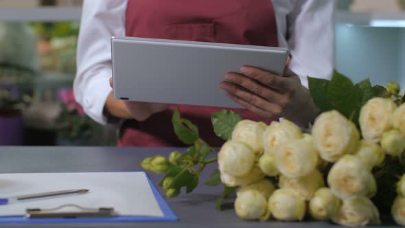 Woman Florist Hands Using Tablet for Taking Orders