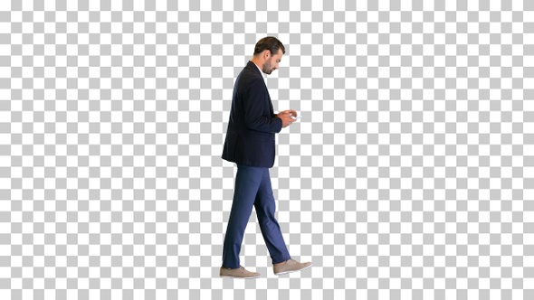 Young businessman walking and texting on his phone, Alpha Channel