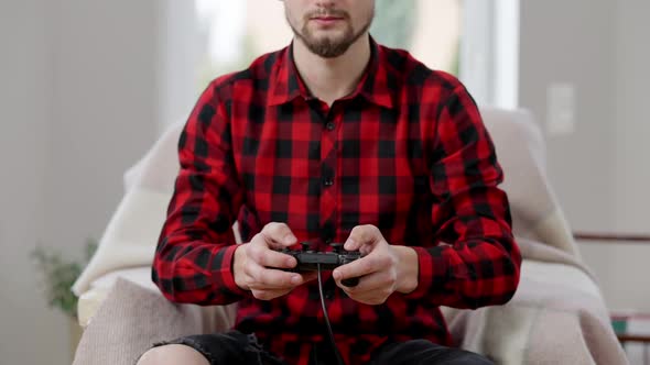 Young Unrecognizable Bearded Man Using Game Controller Indoors