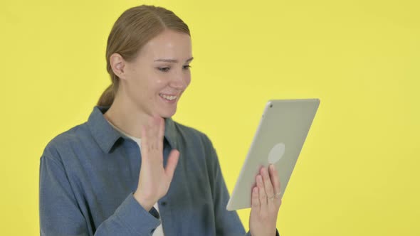 Video Call on Tablet By Young Woman on Yellow Background