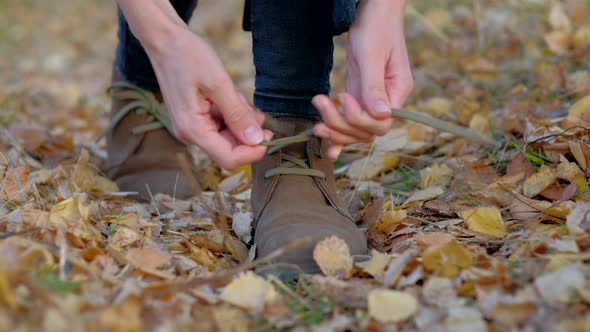 Female tying her shoelaces on her leather shoes