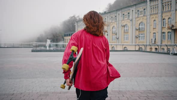 Portrait of a Young Teenager with a Skateboard Under His Arm