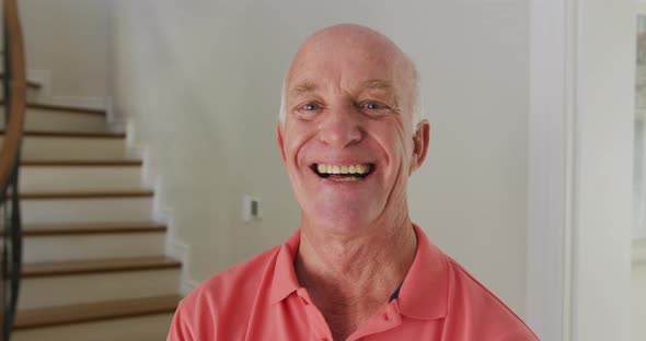 Portrait of smiling senior caucasian man looking at camera at home