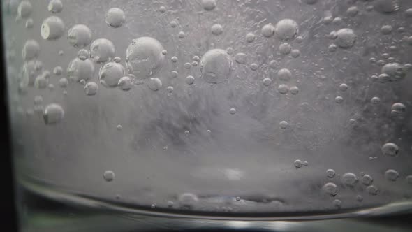 Glass with Clear Sparkling Vitamin Water on Dark Background